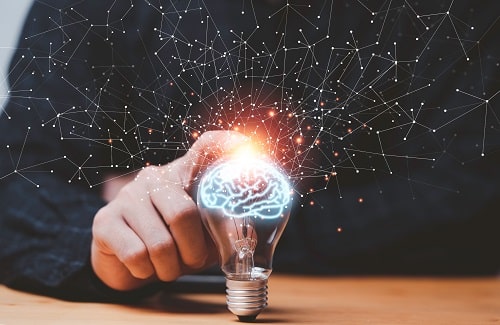 Businessman hand touching lightbulb with glowing virtual brain a